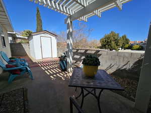 View of patio / terrace featuring a pergola, a fenced backyard, an outdoor structure, and a storage unit