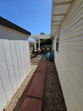 View of side of home with a patio area, fence, and a pergola