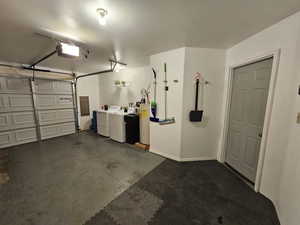 Garage with water heater, a garage door opener, and washer and dryer