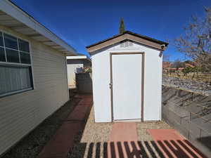 View of shed featuring fence