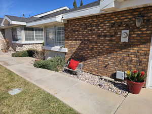 Property entrance with brick siding and roof with shingles