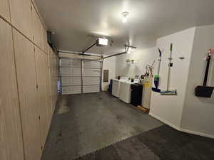 Garage featuring a garage door opener, washer and dryer, and water heater