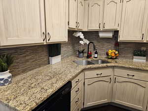 Kitchen featuring dishwasher, light brown cabinets, and a sink