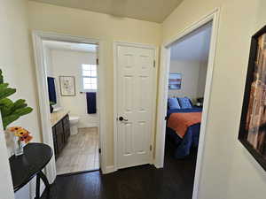 Hall featuring dark wood-style flooring and baseboards