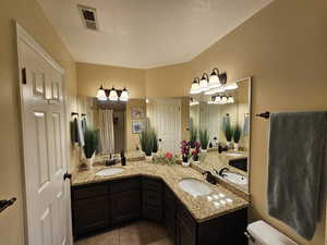 Full bathroom featuring double vanity, a sink, and visible vents