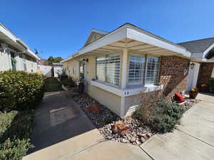 View of side of home featuring brick siding and fence