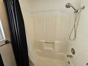 Bathroom with shower / bath combination with curtain