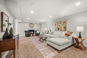 Living area with baseboards, a lit fireplace, recessed lighting, and light colored carpet