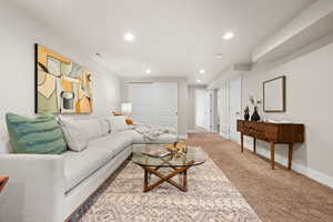 Living area featuring light colored carpet, visible vents, baseboards, and recessed lighting