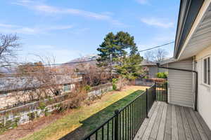 Wooden terrace with a yard, a fenced backyard, and a mountain view