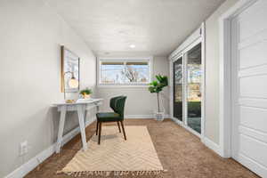 Home office featuring visible vents, baseboards, a textured ceiling, and light colored carpet