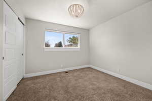 Unfurnished bedroom featuring carpet, a closet, and baseboards