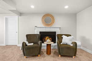 Living area with baseboards, carpet, a glass covered fireplace, and recessed lighting