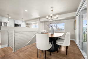 Dining space featuring recessed lighting, a notable chandelier, baseboards, and wood finished floors