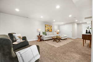 Living room featuring light colored carpet, visible vents, baseboards, and recessed lighting