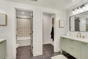 Bathroom featuring visible vents, toilet, shower / bath combo, vanity, and tile patterned flooring