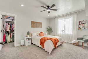 Bedroom featuring light carpet, a closet, a walk in closet, and recessed lighting