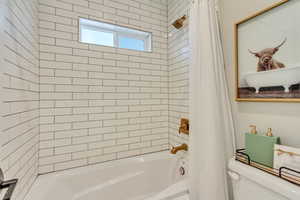 Full bathroom featuring shower / bath combo and toilet