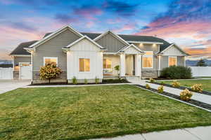 View of front of house featuring a yard, board and batten siding, and stone siding