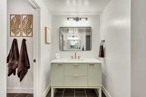 Bathroom featuring vanity, baseboards, and tile patterned floors