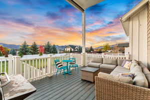 Wooden terrace with outdoor lounge area, a mountain view, and fence