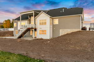 Rear view of house featuring fence, stairway, and board and batten siding