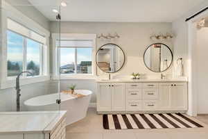 Bathroom featuring recessed lighting, a sink, a freestanding bath, tile patterned floors, and double vanity