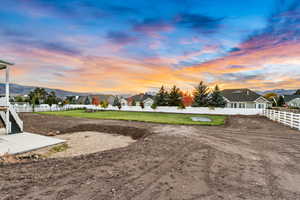 Yard at dusk with fence and a mountain view