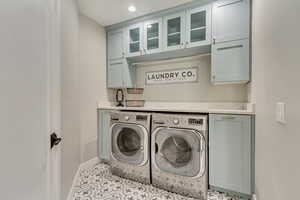 Washroom with washer and clothes dryer, recessed lighting, cabinet space, light tile patterned flooring, and baseboards