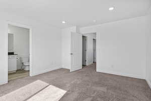 Unfurnished bedroom with light carpet, ensuite bath, baseboards, and recessed lighting