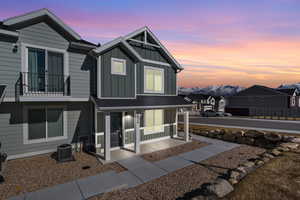 Exterior space with board and batten siding, cooling unit, and a residential view