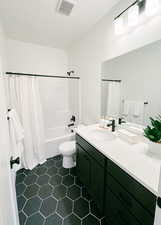 Full bath featuring toilet, shower / bath combo, vanity, and visible vents