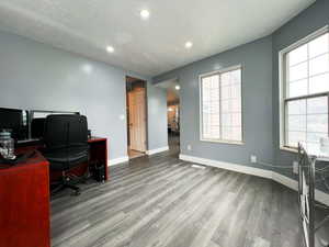 Office featuring a textured ceiling, wood finished floors, and baseboards