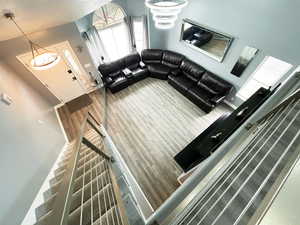 Living area featuring baseboards, a textured ceiling, stairway, and wood finished floors