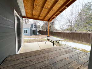 Wooden deck featuring a fenced backyard and an outbuilding