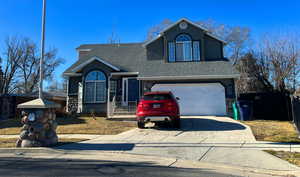 Traditional-style home featuring a garage, stucco siding, concrete driveway, and roof with shingles
