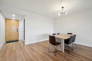 Dining room featuring a chandelier, light wood-style flooring, and baseboards