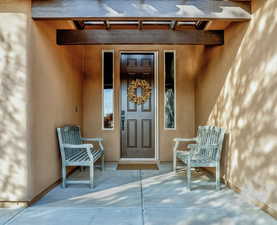 Doorway to property featuring stucco siding