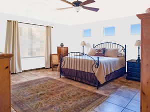 Bedroom with ceiling fan and tile patterned flooring