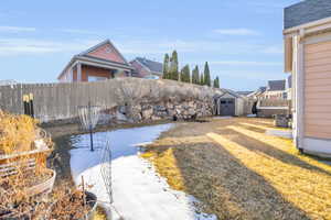 Exterior space with a shed, a shed, rock wall and fence