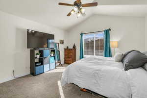 Bedroom with carpet flooring, vaulted ceiling, baseboards, and ceiling fan