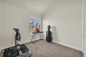 Workout room with light carpet, vaulted ceiling, and baseboards