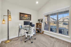 Office area featuring baseboards, visible vents, vaulted ceiling, carpet flooring, and recessed lighting