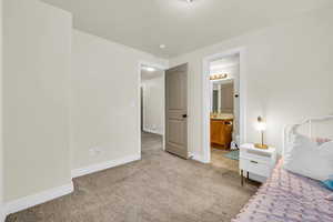 Bedroom with light carpet, ensuite bath