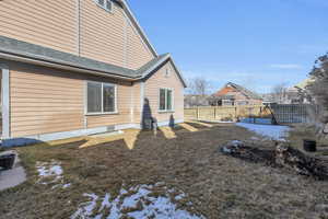 Rear view of house with a yard, raised garden boxes, roof with shingles, and fence private yard