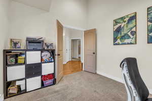 Carpeted home office featuring baseboards