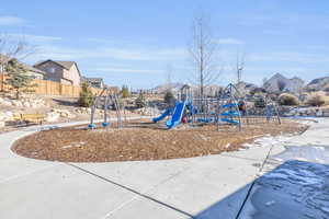 Community jungle gym featuring fence and a residential view