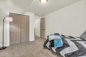 Bedroom with  a closet, and light colored carpet