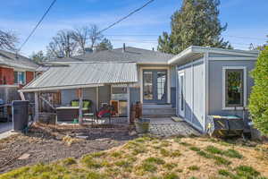 Back of property with entry steps, brick siding, a shingled roof, french doors, and a patio area