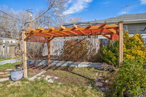 View of yard featuring fence and a pergola